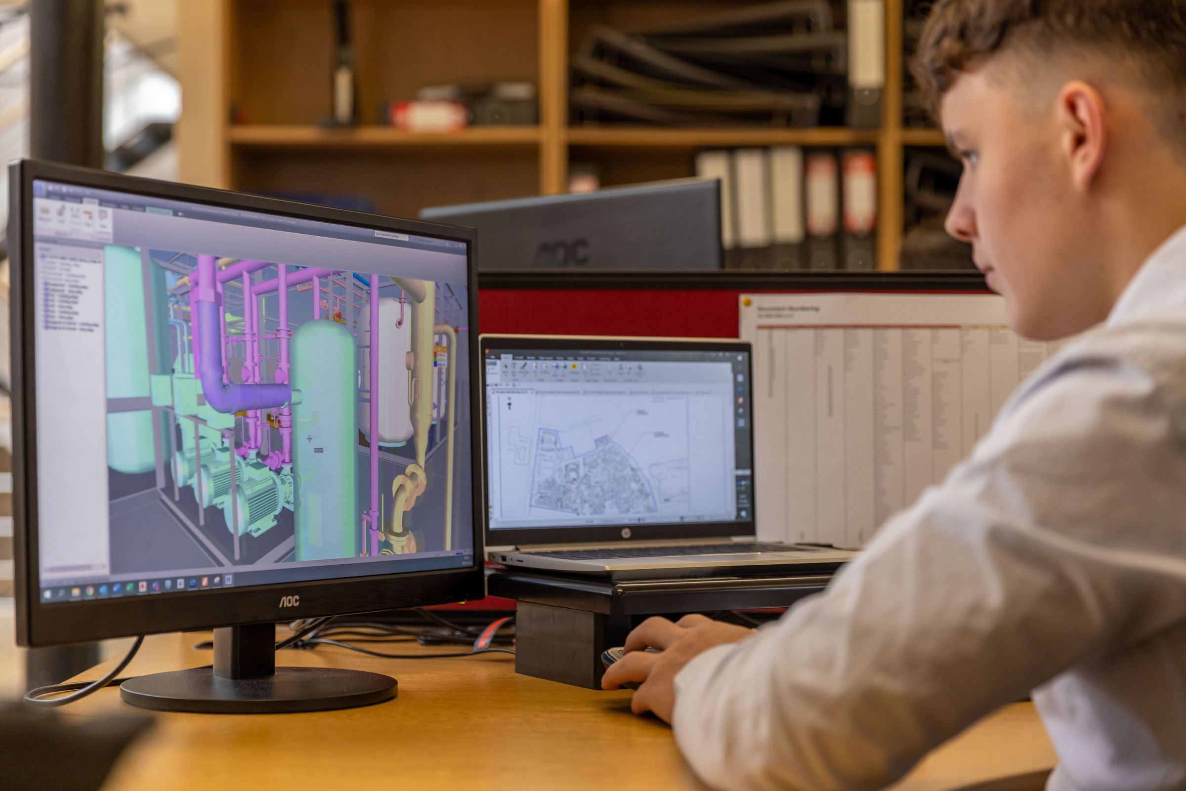 Engineer working on a 3D machine model in CAD