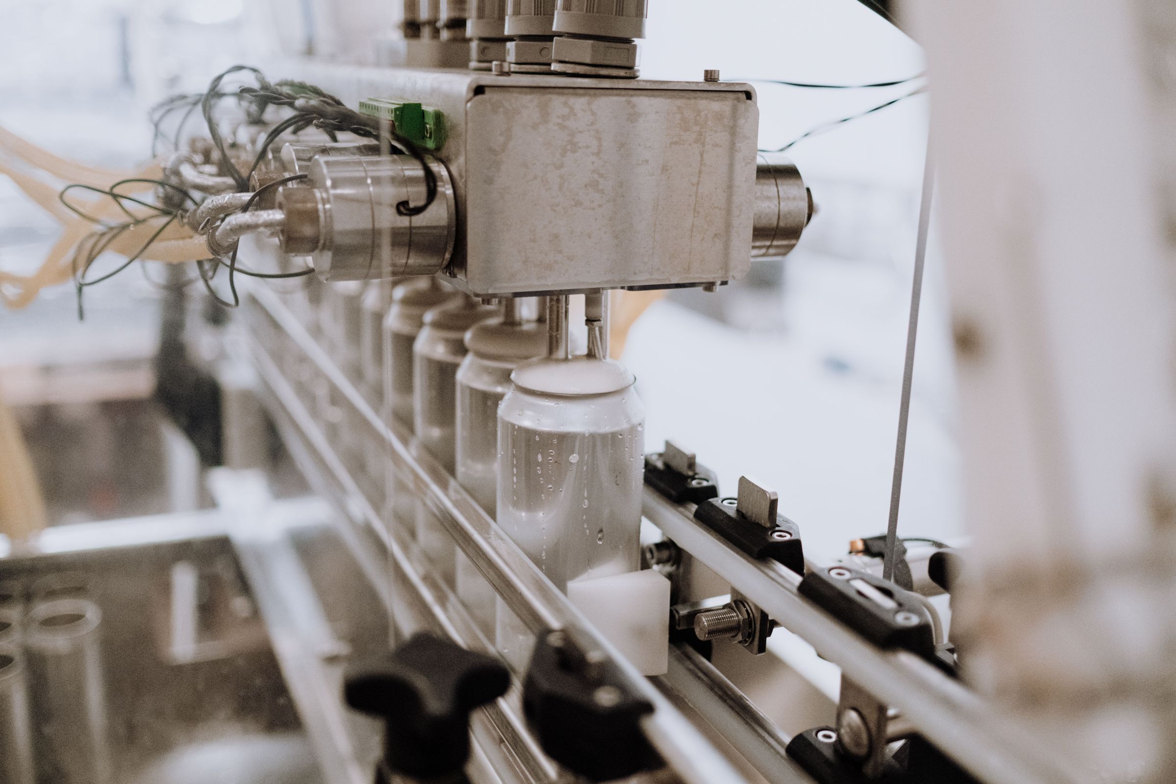 Filling line feeding containers under dispensing nozzles