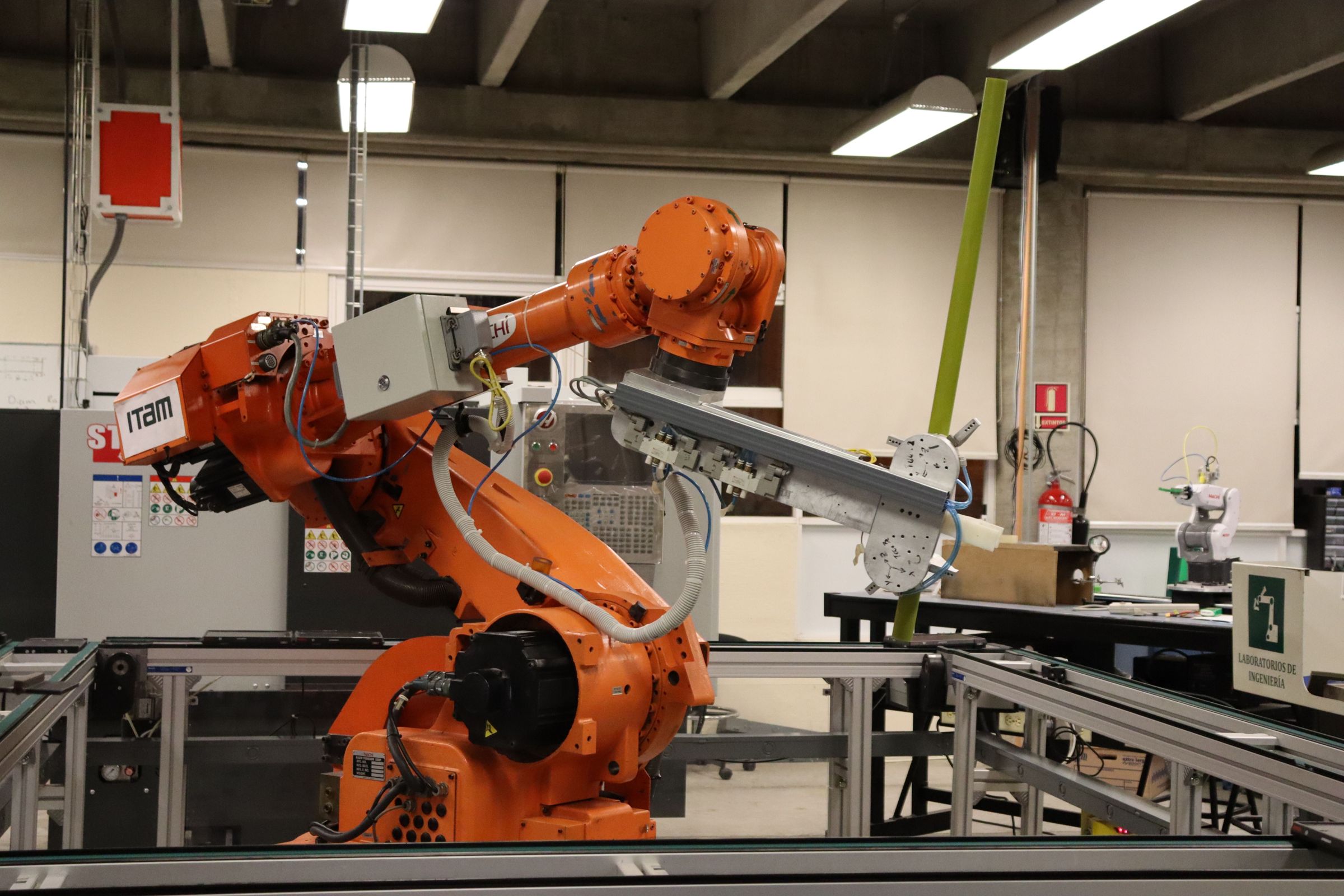 Industrial robot with cable dress pack and end-of-arm tooling over a conveyor